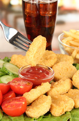 Fried chicken nuggets with vegetables,cola,french fries and