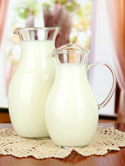 Pitchers of milk on table in room