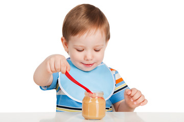 Boy eats with a spoon puree