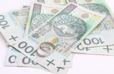 Obraz na płótnie Canvas Wedding rings and money on a white background