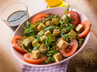 salad with tofu tomatoes arugula and sesame seeds