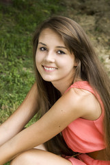 Naklejka premium Pretty happy young brunette posing outdoors .