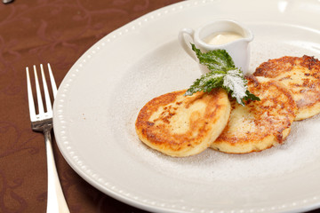 Obraz na płótnie Canvas Cheese pancakes with sour cream