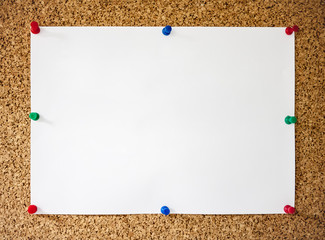 White paper pinned on cork board
