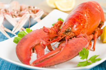 Lobster and lemon wedges. Langoustines in background.