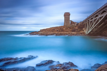 Calafuria Tower landmark on cliff rock, bridge and sea. Italy.
