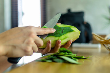 The wooman is peeling a mango