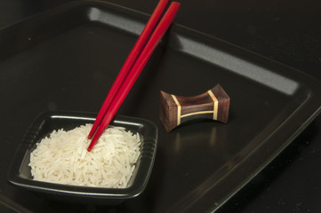 Reisschüssel mit Reis und Stäbchen