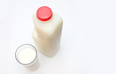 glass of milk with carton behind