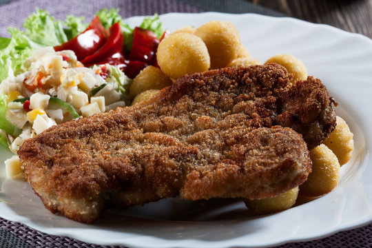 Breaded chop, prepared potatoes and salad. Mysterious light
