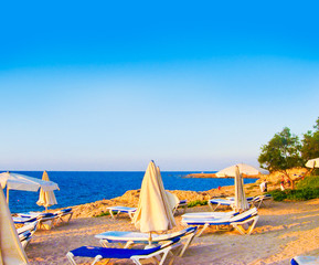 Fototapeta na wymiar Beautiful sunny lounges near the pool over blue bright evening s