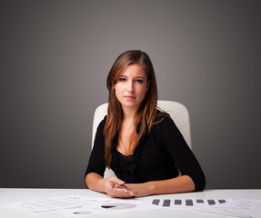 Businesswoman sitting at desk and doing paperwork