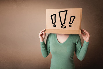 Young lady gesturing with a cardboard box on her head with excla