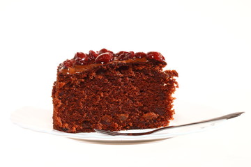 Piece of chocolate cake with icing and cherry