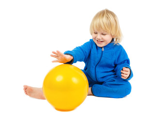 Fototapeta na wymiar Cute baby boy plays with yellow ball