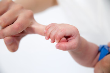 Baby hand holding mother finger