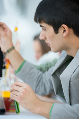 Male student with group of classmates on background working at t