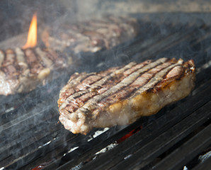 beef steak cooking on an open flame grill