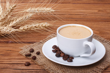 coffee and ears of barley on wooden table