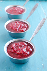 Raspberry sauсe on blue wooden background