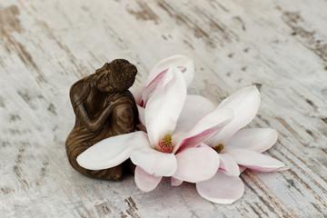 Buddhafigur mit Magnolienblüte