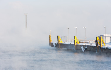 Misty sea and shipping docks in port