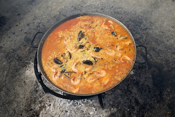 Spanish Paella cooking in a pan on hot embers