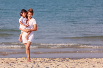 Asian woman hold the boy on beach
