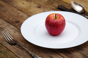 roter Apfel auf weißem Teller