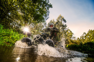 Quad rider through water stream © homydesign
