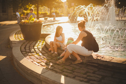 Family sitting by a fountain