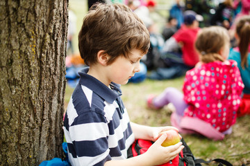 Boy sitting by a tree