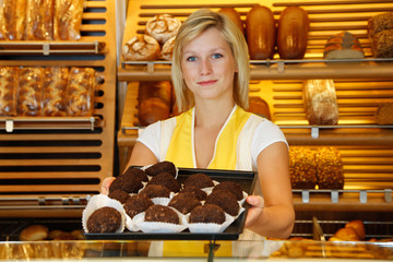 Shopkeeper in bakery presents tablet of rum balls