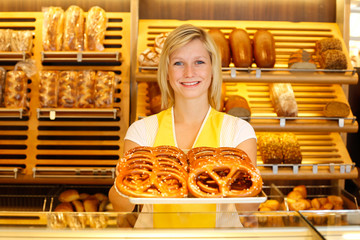 Shopkeeper in bakery with tablet of pretzels
