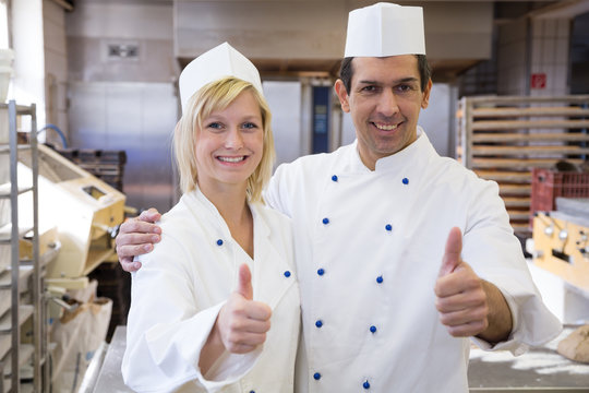 Two bakers showing thumbs up in bakeshop