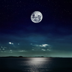 Fototapeta na wymiar Księżyc w pełni odzwierciedlone na plaży