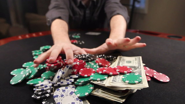 A gambler at a poker table goes all in, then lays down a pair of aces.