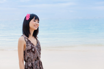 a young asian woman relaxing on the beach