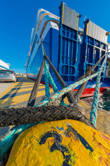 Greece Piraeus,Yellow rusty metal bollard and ship rope harbor a © korpithas