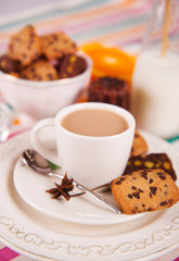 cup of hot coffee with milk and sweet cookie