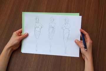 designer assessing fashion drawings