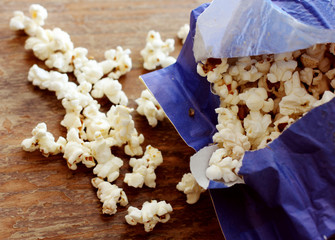 popcorn in a paper bag on a wooden background