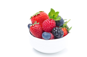 Assorted berries in a white bowl isolated on white