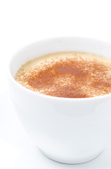 Cappuccino with cinnamon in a white cup closeup