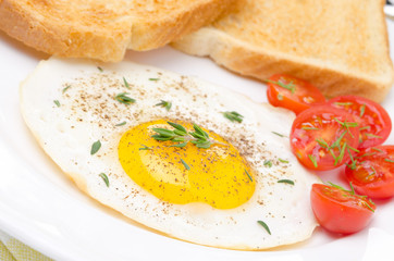 Fried eggs, fresh tomatoes and crunchy toast for breakfast