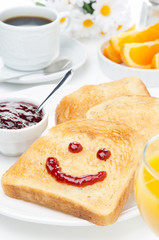 Toast with a smile of jam, coffee, orange juice and fresh orange