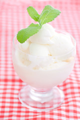 ice cream with mint in a glass bowl on plaid fabric