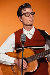 Retro fifties musician with glasses playing acoustic guitar. Stu