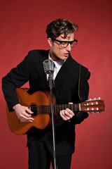 Retro fifties musician with glasses playing acoustic guitar. Stu