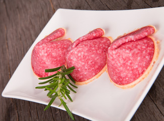 tasty slices of ham, on the round plate and wood 